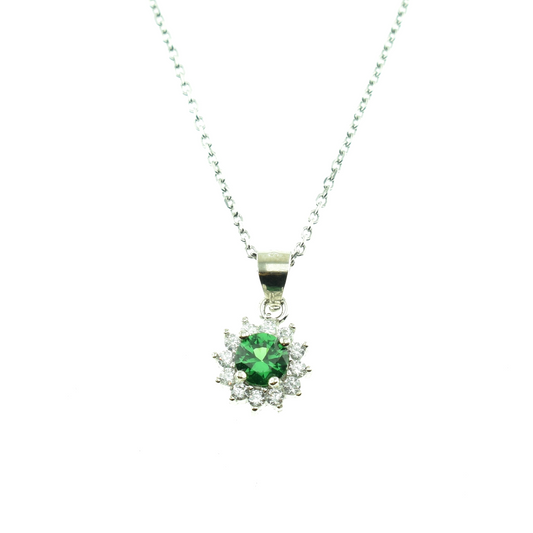 A silver necklace with a floral pendant featuring a green gemstone and white crystals, presented on a box.